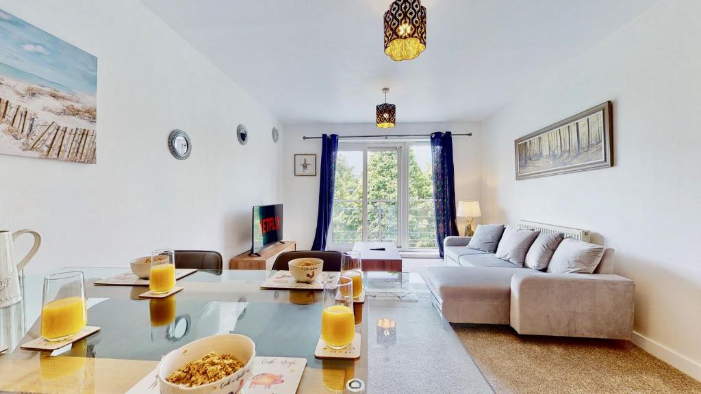 uma sala de estar com um sofá e uma mesa em Riverside Apartment with Parking 1 Mile from Town Centre em Kent