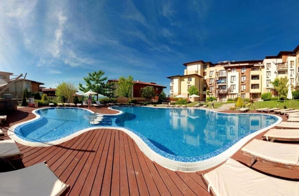 uma grande piscina com cadeiras e edifícios em PSB Apartments in Gardens of Eden em Sveti Vlas