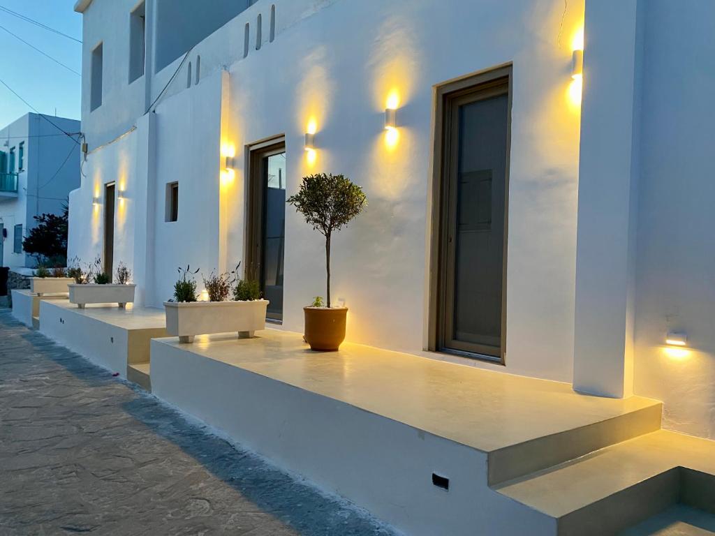 un edificio blanco con macetas. en Asteras Cozy Stay, en Naousa