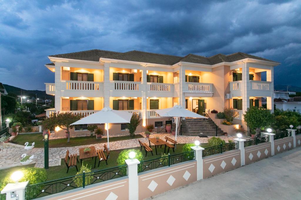 un grand bâtiment avec des tables et des parasols la nuit dans l'établissement Lady Elena Hotel, à Ammoudia