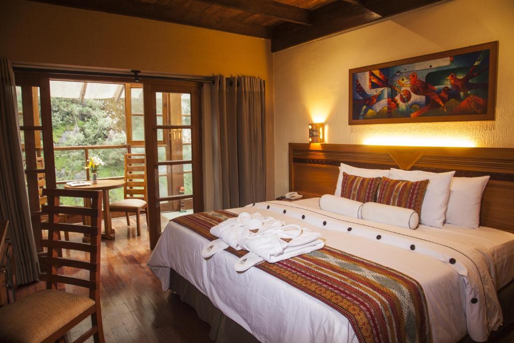 ein Schlafzimmer mit einem großen Bett mit Handtüchern darauf in der Unterkunft Casa del Sol Machupicchu in Machu Picchu