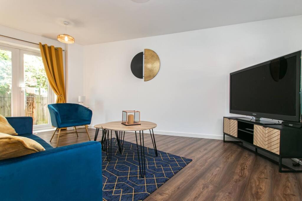 a living room with a blue couch and a tv at Central Stylish House in Colchester in Colchester