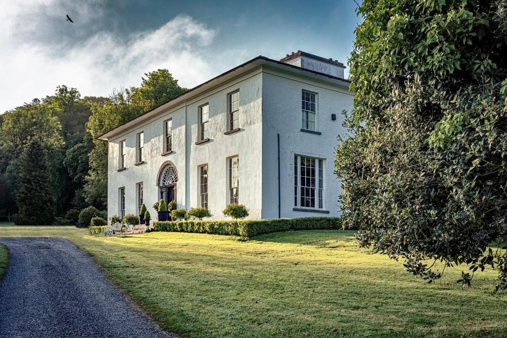 ein großes weißes Haus auf einem Grasfeld in der Unterkunft Noan Country House B&B in Cashel