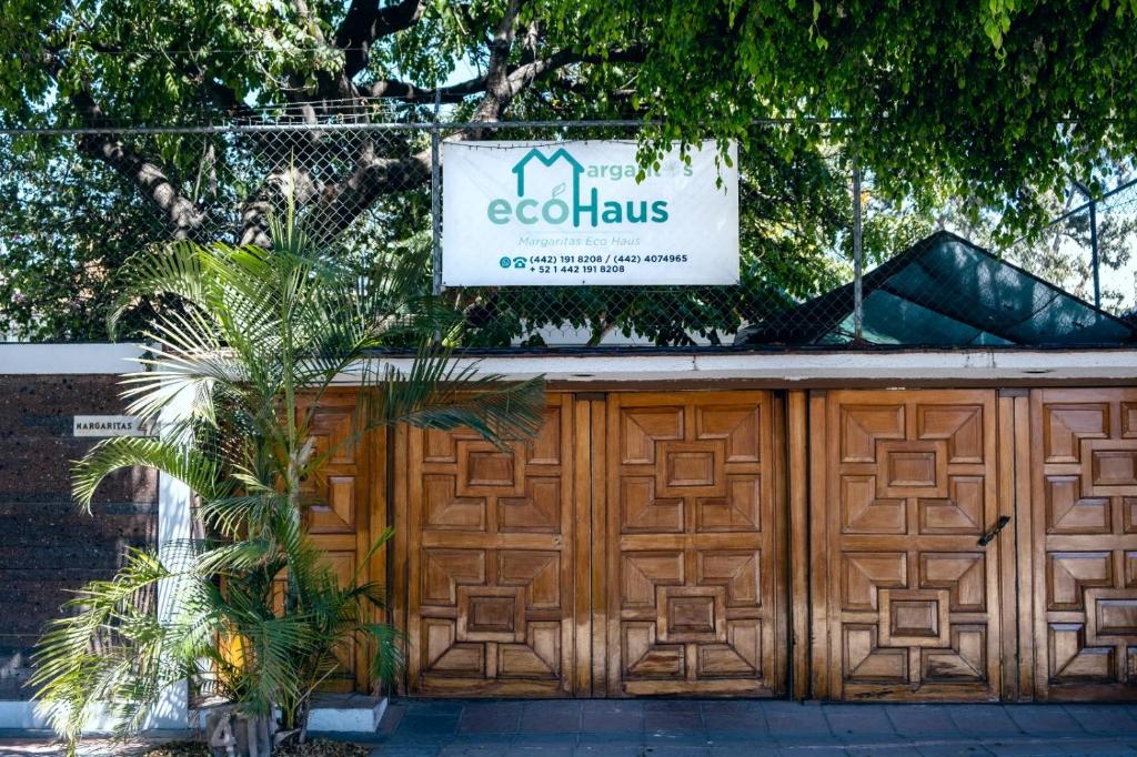 a sign above a wooden garage door with a fence at Margaritas Eco Haus in Querétaro