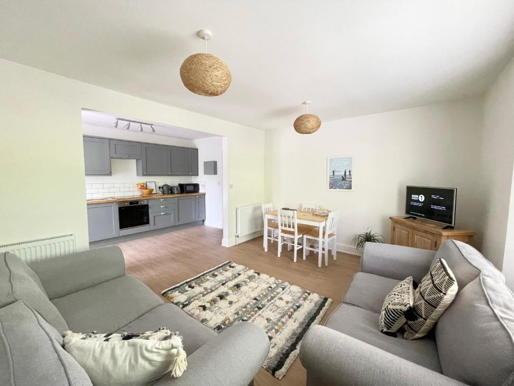 a living room with two couches and a kitchen at Lincombe Court Apartment Wellswood Torquay in Torquay