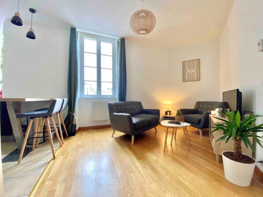 un soggiorno con divano, sedie e tavolo di Superbe appartement avec parking a Caen