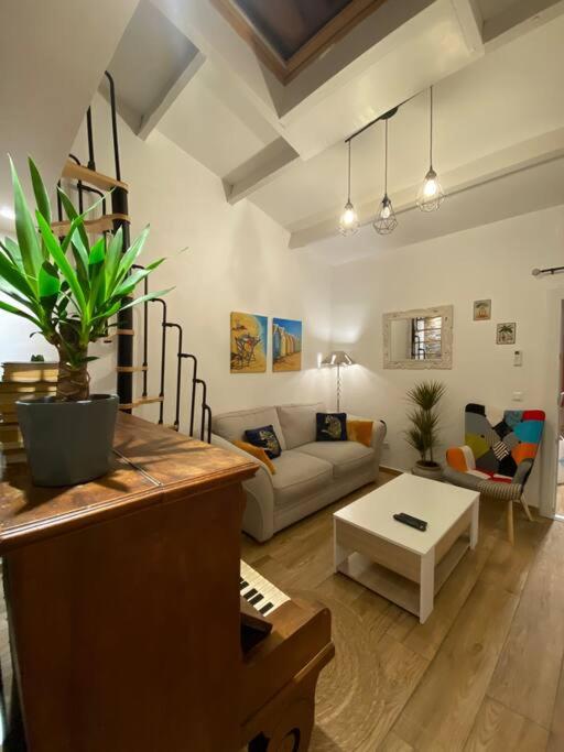 a living room with a couch and a table at Charmante maison avec extérieur à deux pas des remparts in Aigues-Mortes