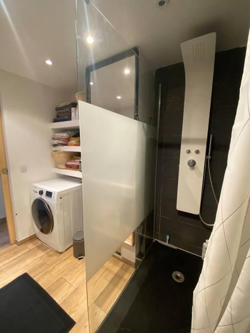 a bathroom with a glass door and a washing machine at Charmante maison avec extérieur à deux pas des remparts in Aigues-Mortes
