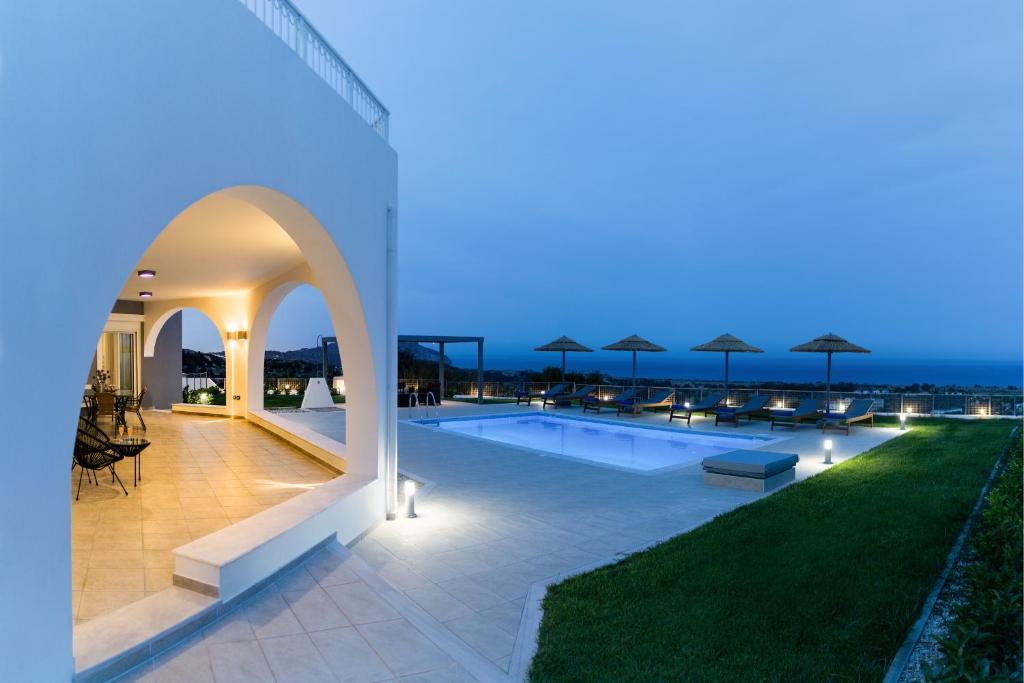 a view of a swimming pool at night at Villa Arco Bianco in Afantou