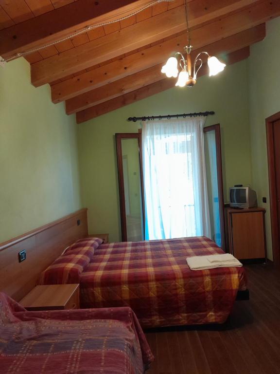 1 dormitorio con 2 camas y ventana en agriturismo AI COLORI, en Paese