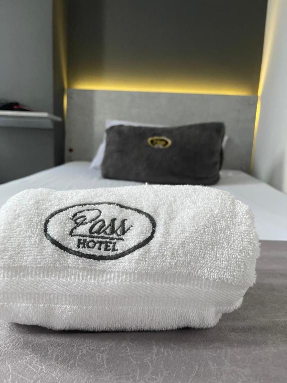 a white towel sitting on top of a bed at Hotel Pass, Laureles Medellín in Medellín