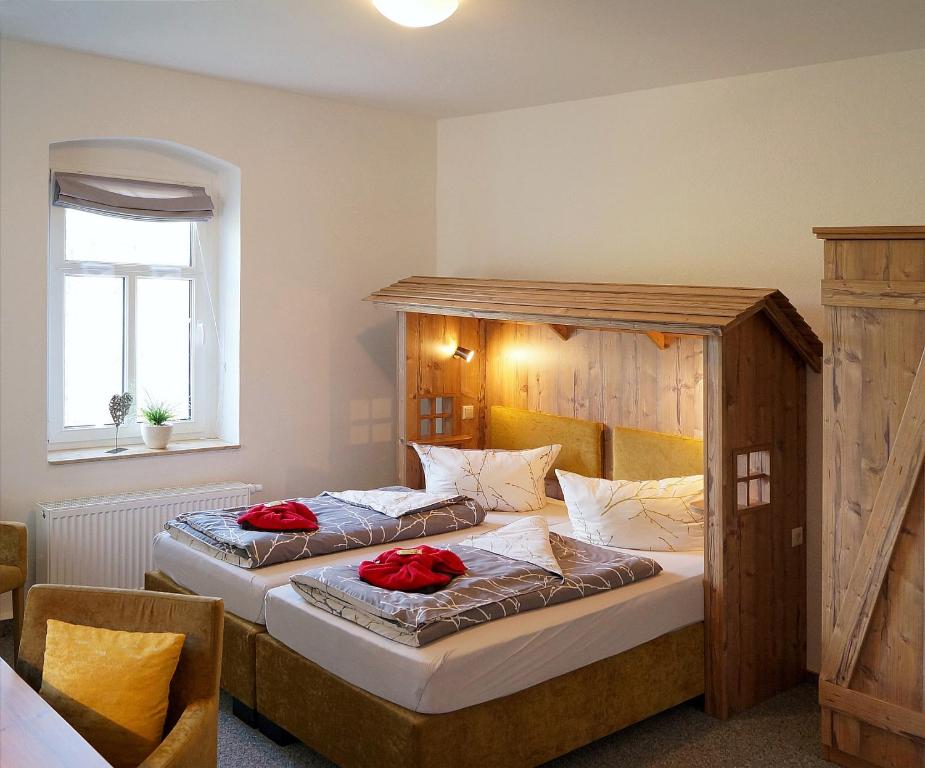 a bedroom with two beds with red pillows on them at Erzgebirgshotel Misnia Bärenfels in Kurort Altenberg