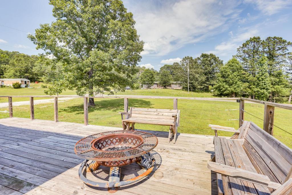 una mesa de picnic y un banco en una terraza de madera con un campo en Jacksonville Home with Deck - 30 Mi to Talladega!, en Jacksonville