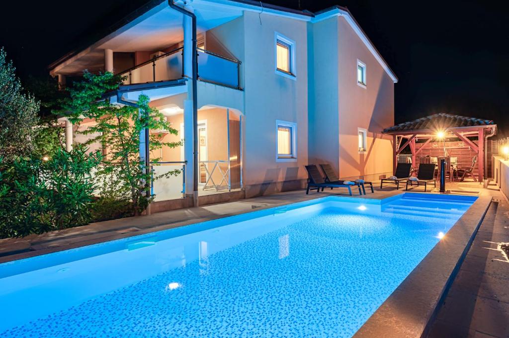 a villa with a swimming pool at night at Apartments Lara in Medulin