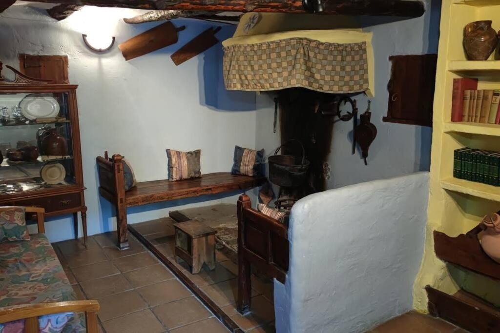 a room with a table and a bench in a room at Casa Rural Obrador. in Montoro de Mezquita