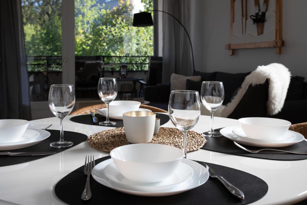 einen Tisch mit schwarzen Servietten, weißen Tellern und Gläsern in der Unterkunft Ferienappartement Winterberg - Bikepark um die Ecke in Winterberg