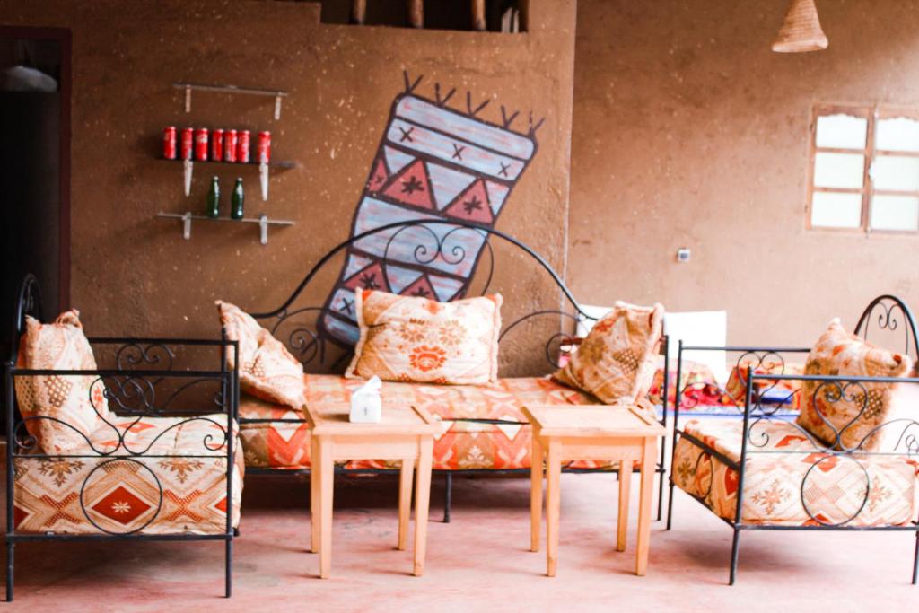 ein Wohnzimmer mit einem Sofa und 2 Stühlen in der Unterkunft da housa hostel in Tahliouine
