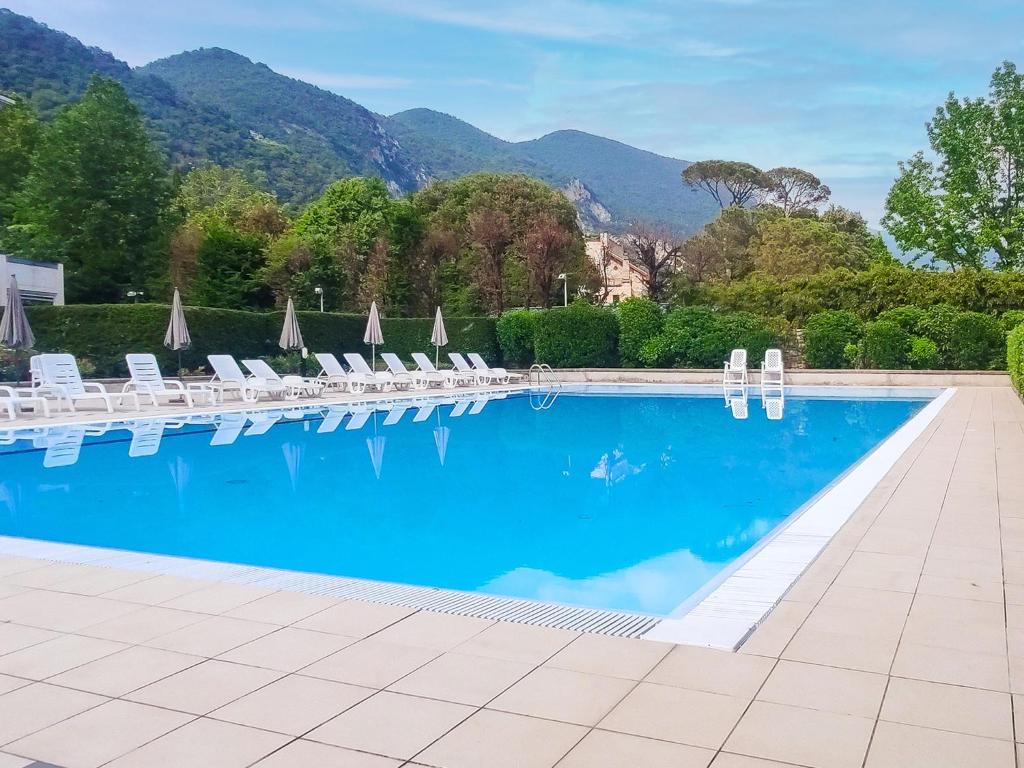 una gran piscina con sillas y sombrillas en Volo di Libellula - close to the Lake and city centre, en Sarnico