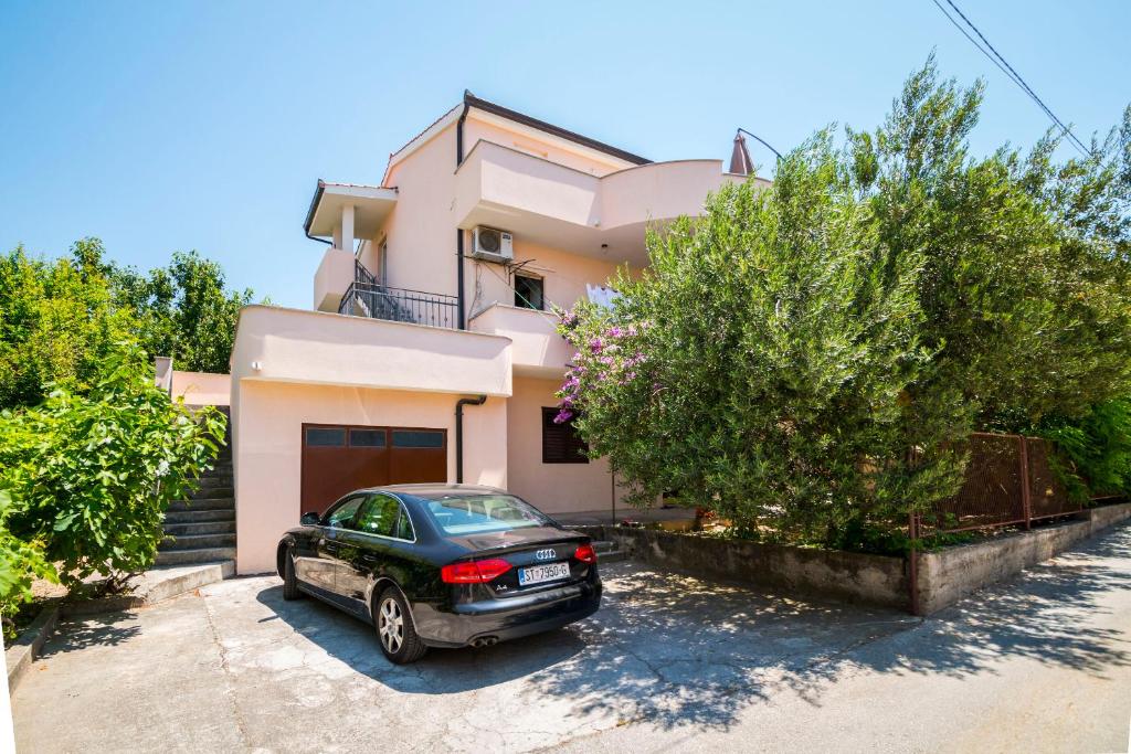 a car parked in front of a house at Apartment Hilda in Solin