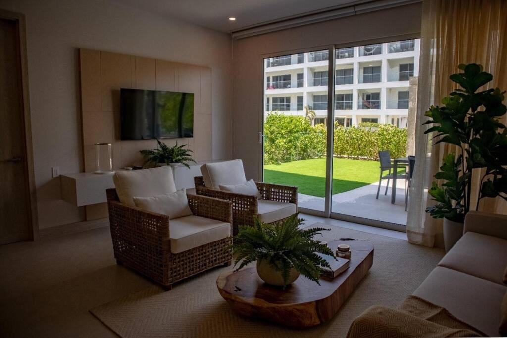 uma sala de estar com um sofá e cadeiras e uma televisão em Apartamento con piscina privada Morros Io em Cartagena de Indias