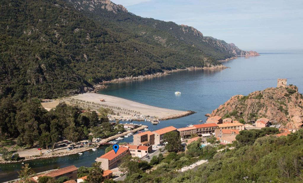 a town on a hill next to a body of water at Résidence Hotelière Capu Seninu in Porto Ota