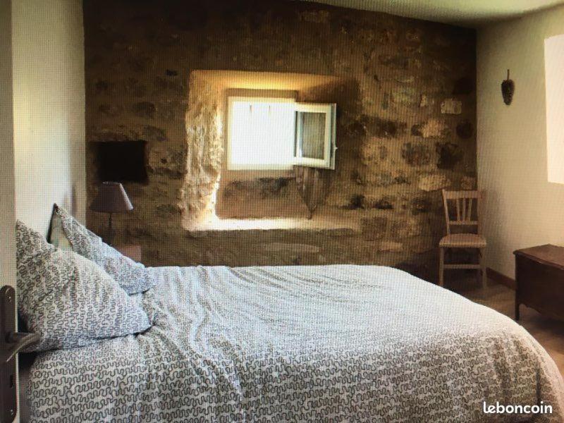 een slaapkamer met een groot bed en een raam bij Mas cœur de Lozère 