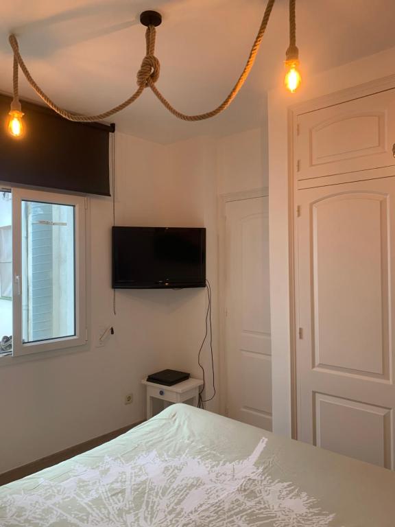 1 dormitorio con 1 cama y TV en la pared en Pals apartament centric en Pals