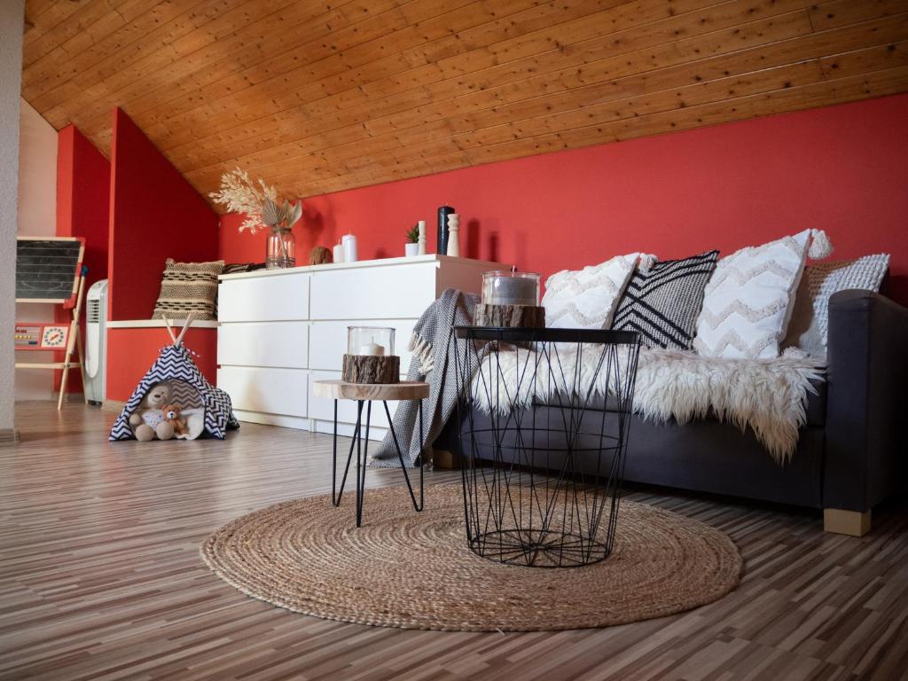 ein Wohnzimmer mit einem Sofa und einer roten Wand in der Unterkunft Chata Laci na Kamenci in Kaluža