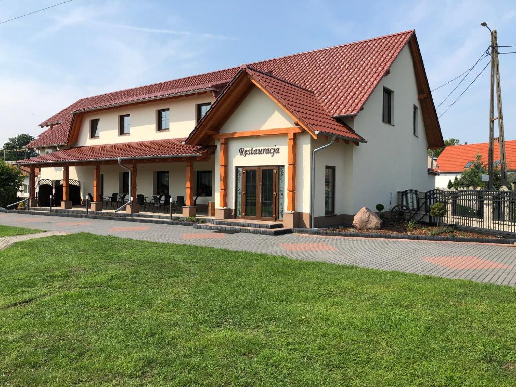 un edificio blanco con techo rojo en Restauracja & Bar u Dudy, en Chrząstowice