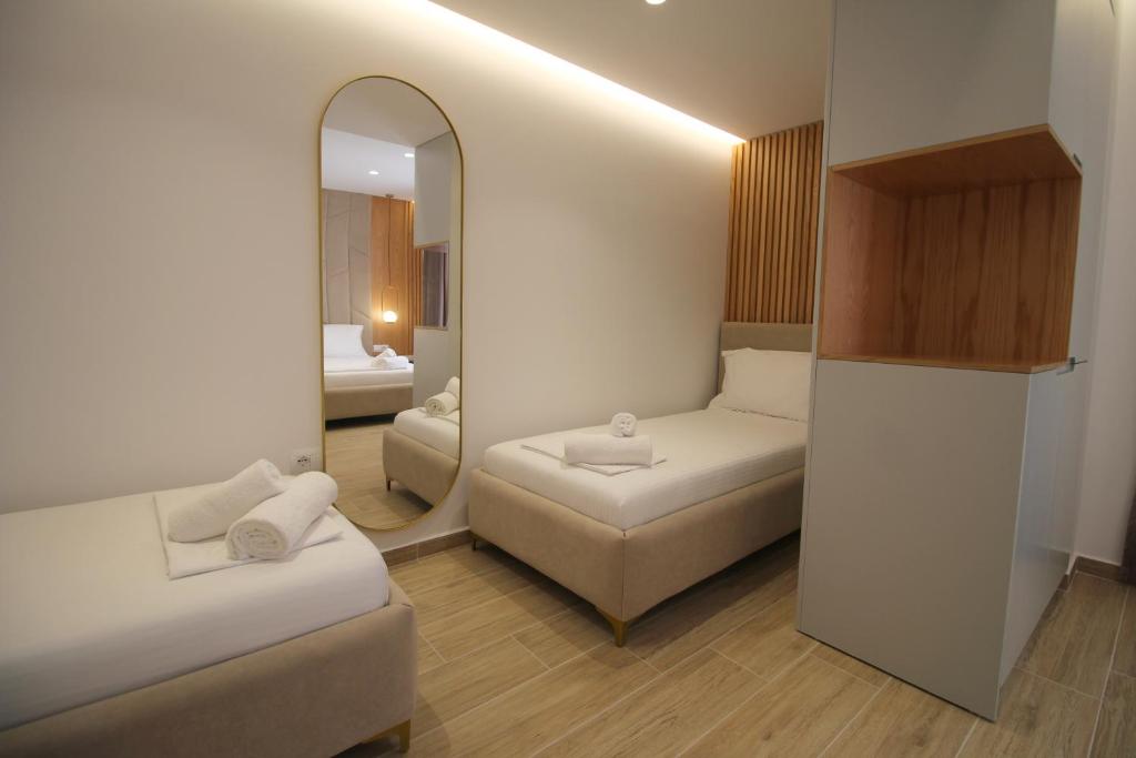 a small room with a mirror and a couch at Julia Hotel in Sarandë
