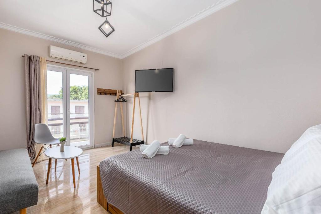 een slaapkamer met een bed en een tv aan de muur bij Luna solari Apartment in Mantoúkion