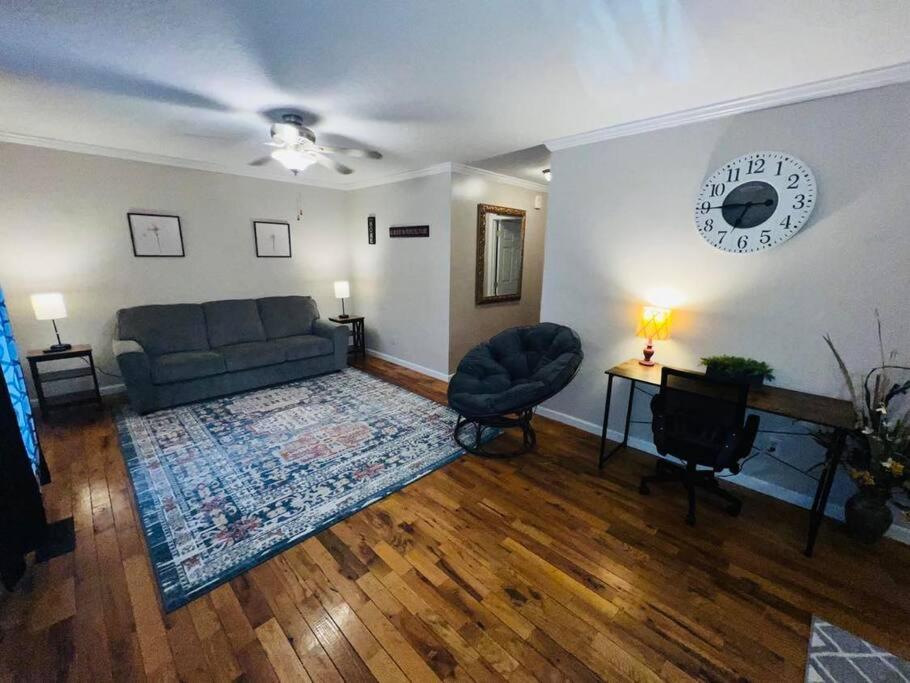 una sala de estar con un sofá y una mesa en Tranquil Townhouse Near Lake, en Guntersville
