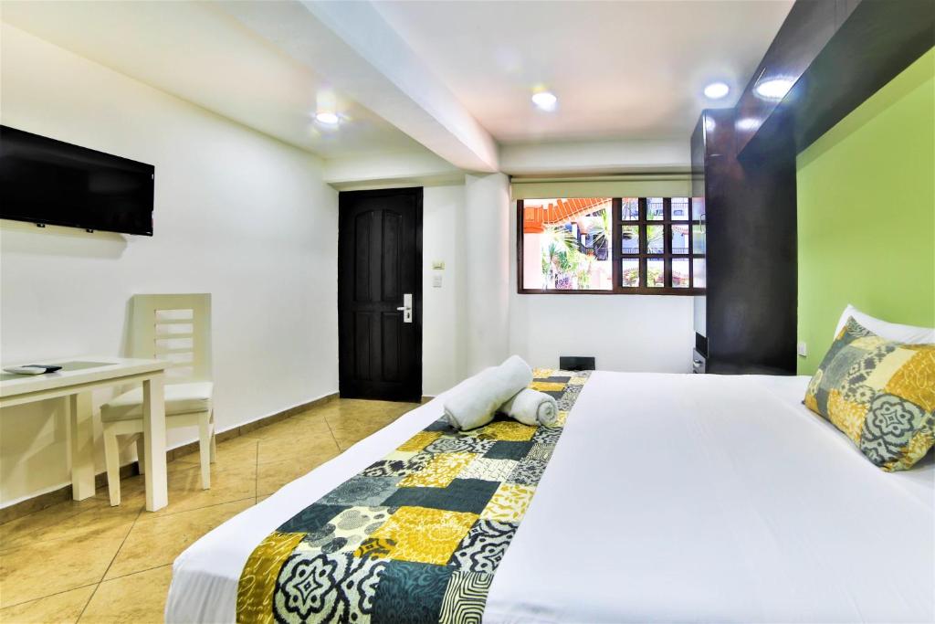 Кровать или кровати в номере Hotel Colonial Playa del Carmen
