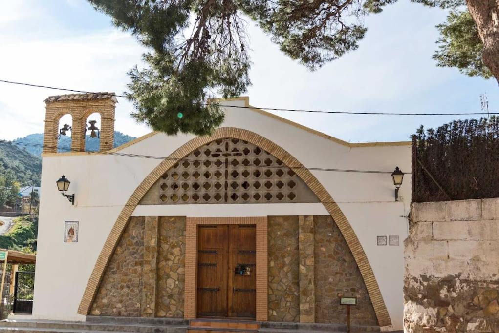 una iglesia con un arco delante de un edificio en Piso Sierra Calderona a 15 minutos del mar Estivella, en Estivella