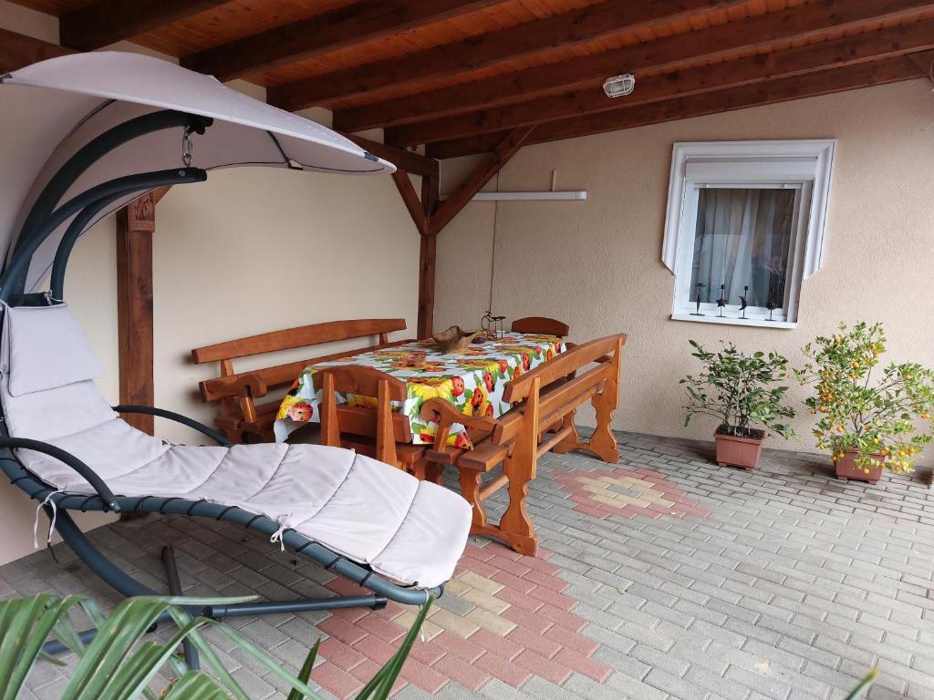 een patio met een tafel, een stoel en een parasol bij Biagio apartman in Balatonlelle