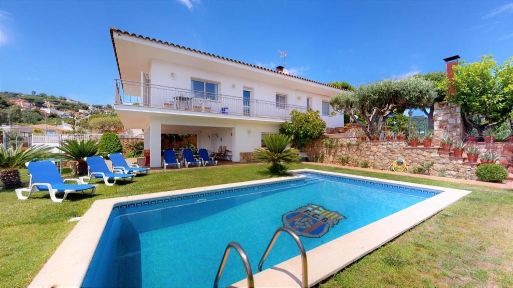 una villa con piscina di fronte a una casa di VILLA VALENTINA a Mataró