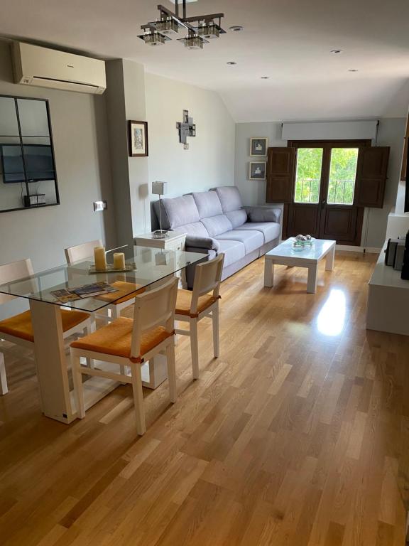 a living room with a glass table and a couch at VUT Dúplex Miraluz in Cuenca