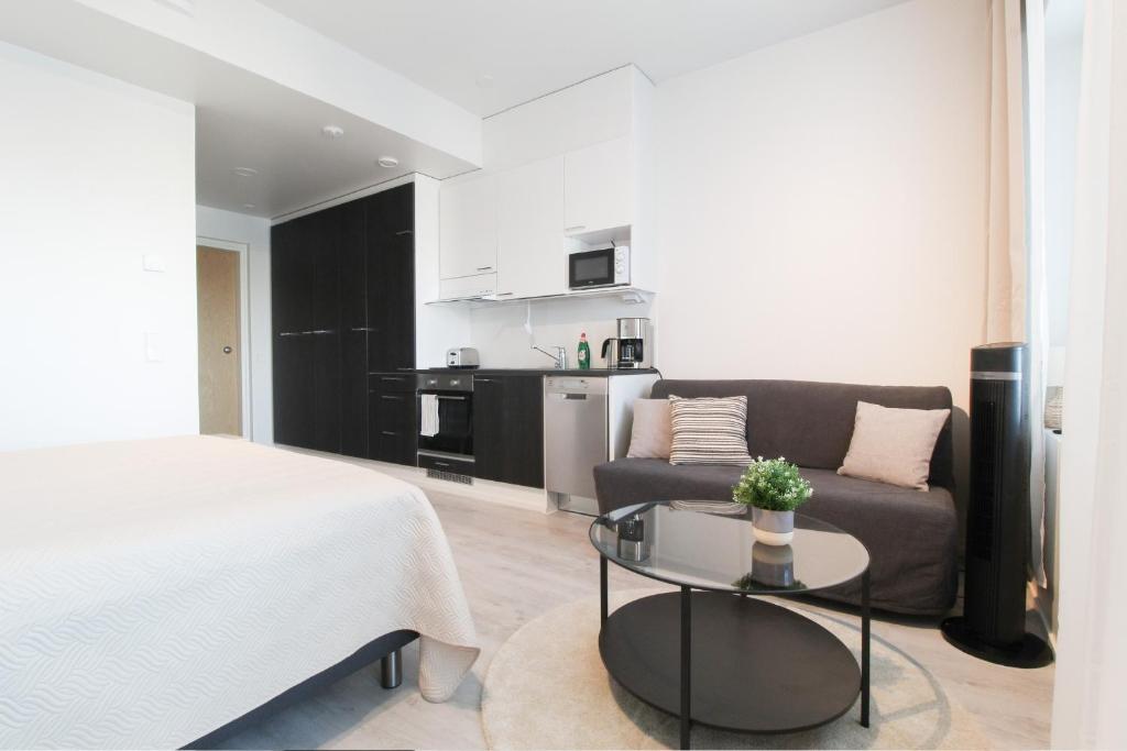 Habitación con cama, sofá y mesa. en City Apartment Tornitupa, en Kuopio