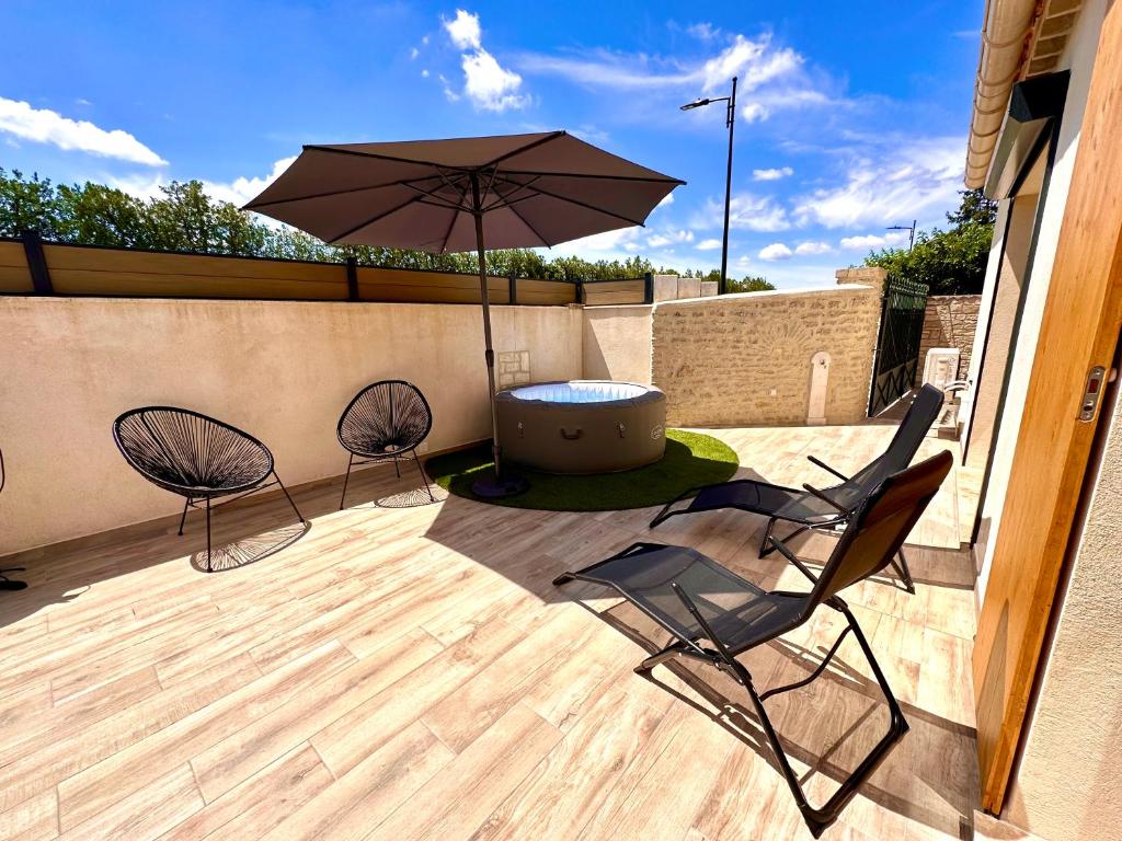 - 2 chaises et un parasol sur la terrasse dans l'établissement Maison de charme avec Jacuzzi, à Mollégès