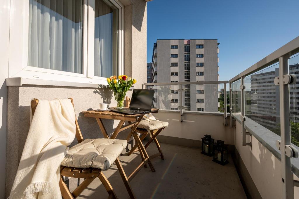 een balkon met een tafel en een laptop. bij INKANTO in Katowice