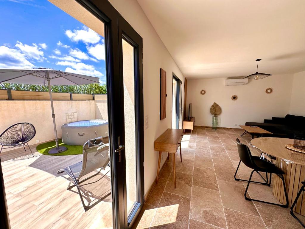 a room with a patio with a table and a tub at Maison de charme avec Jacuzzi in Mollégès