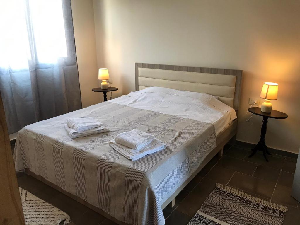 a bedroom with a bed with two towels on it at Countryside Cozy Appartaments in Vlorë