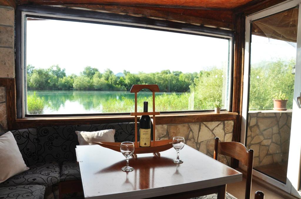 eine Flasche Wein auf dem Tisch mit zwei Gläsern in der Unterkunft Skadar Lake House Virpazar in Virpazar
