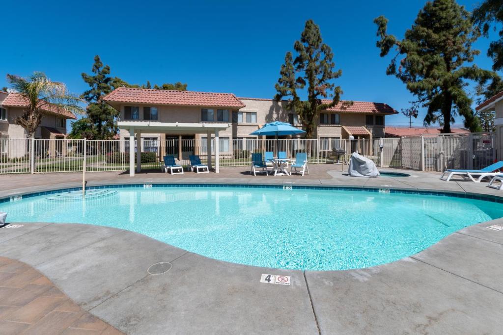 ein großer Pool mit Stühlen und ein Haus in der Unterkunft Indian Palms Vacation Club in Indio