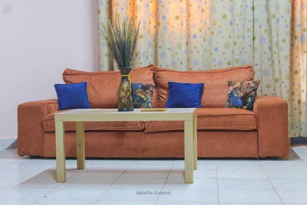 a couch with a table and a vase on it at Ranya in Bobo-Dioulasso