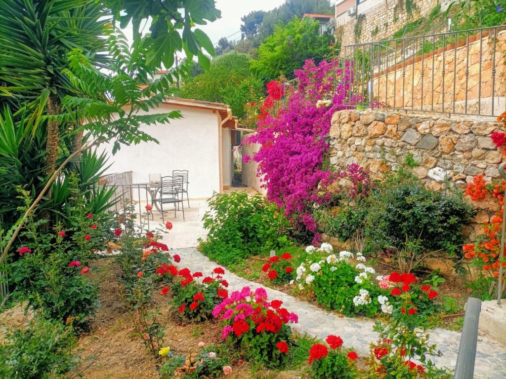 um jardim com flores coloridas e uma parede de pedra em Petit coin de Paradis a cote de Monaco em Roquebrune-Cap-Martin