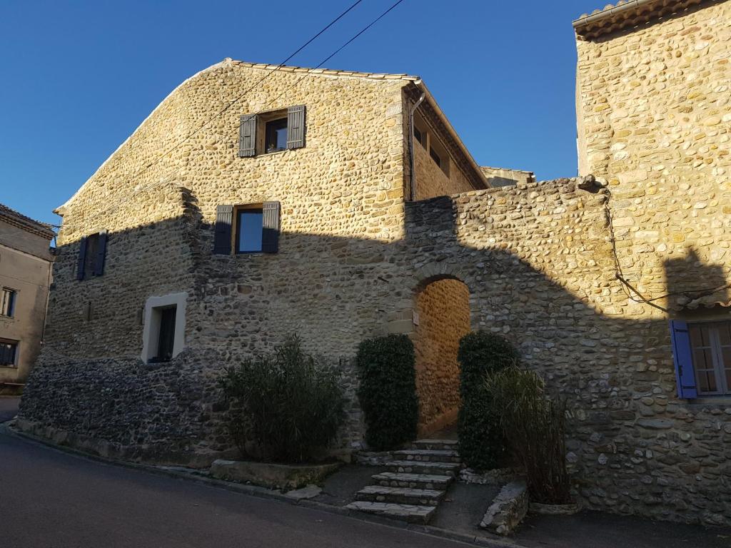 a brick building with a shadow on the side of it at L'ENTRE POTES - Maison de caractère climatisée avec garage in Villedieu