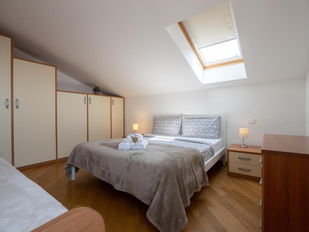 Schlafzimmer im Dachgeschoss mit einem Bett und einem Fenster in der Unterkunft Appartamento Pesco "A Casa Felice" in Pietra Ligure