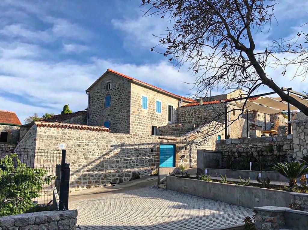 a building with a blue door on the side of it at Skalina House in Tivat