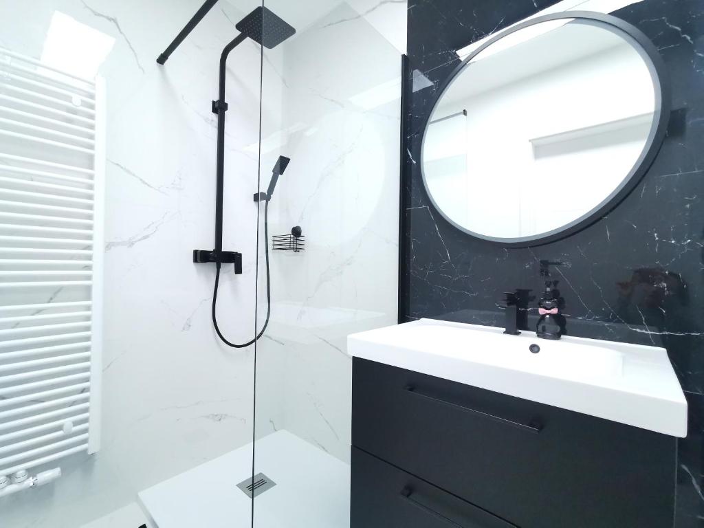 a bathroom with a sink and a mirror at Plażowa Park Apartamenty in Międzywodzie